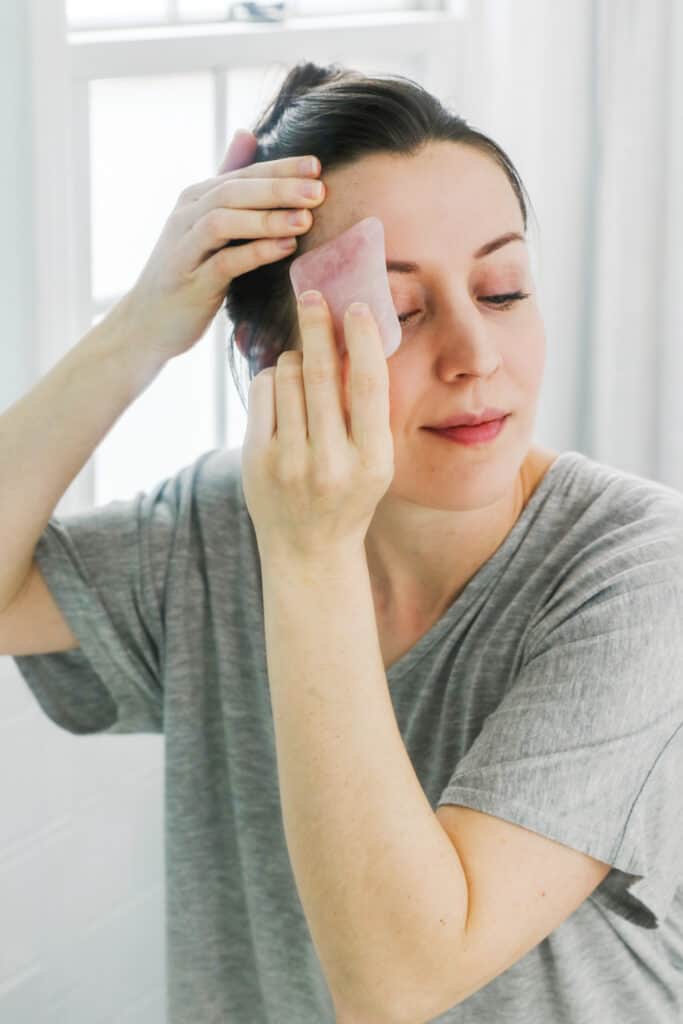 Massaging Forehead with Gua Sha stone