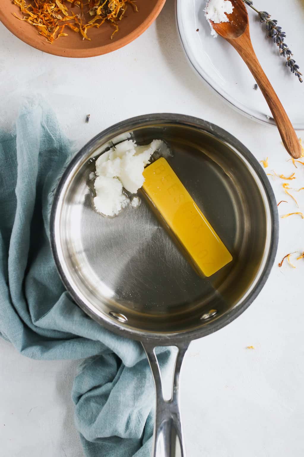 Melting shea butter and beeswax for bug bite balm