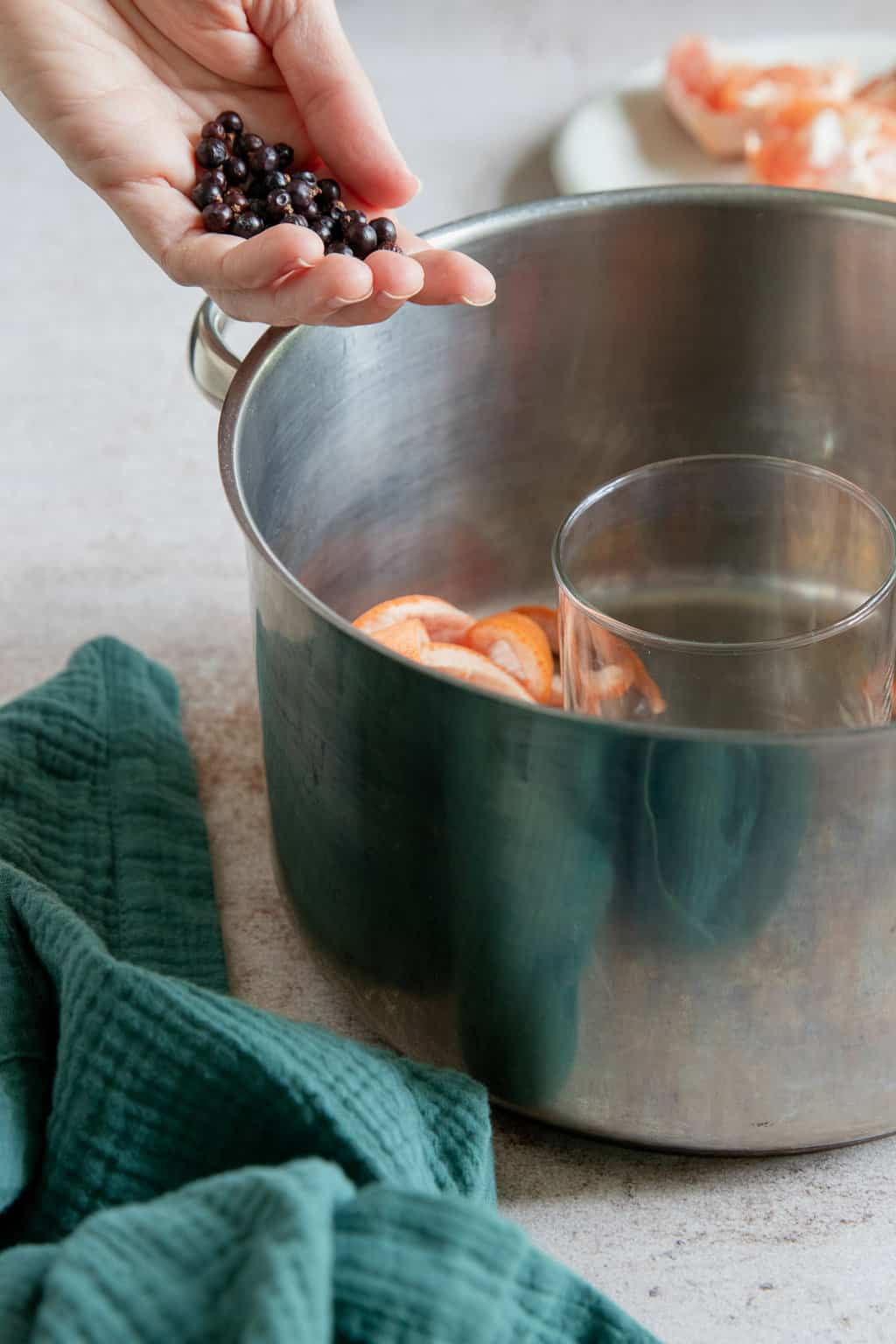 Making homemade hydrosol with grapefruit peel and dried juniper berries