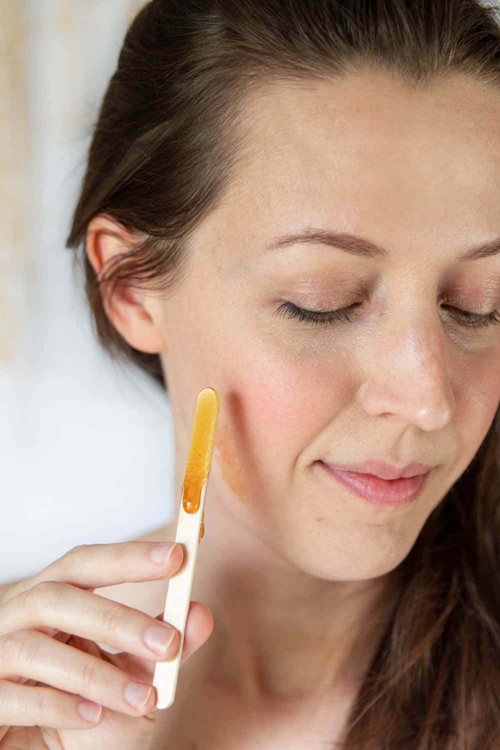 Applying sugar wax to the face