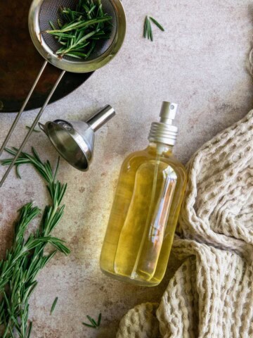 Strain out rosemary herbs and spritz rosemary water onto hair