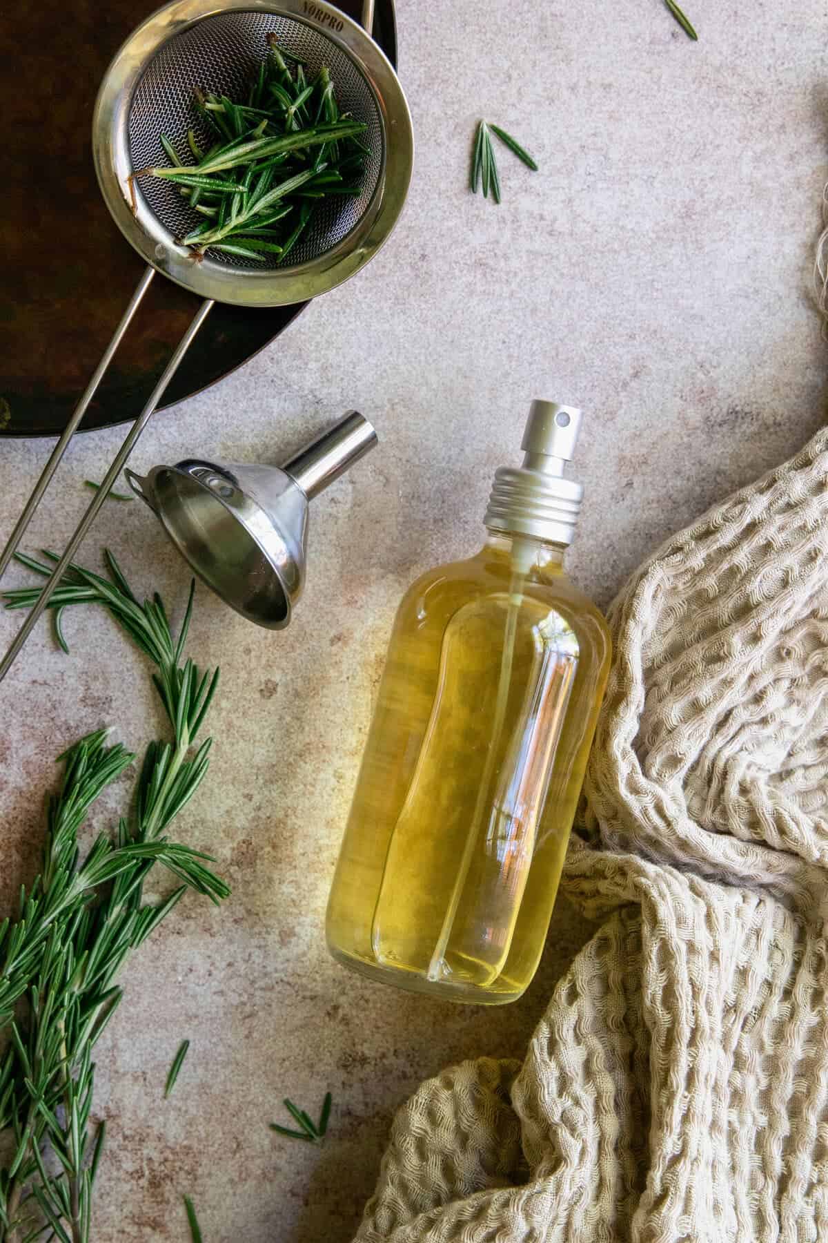 Strain out rosemary herbs and spritz rosemary water onto hair