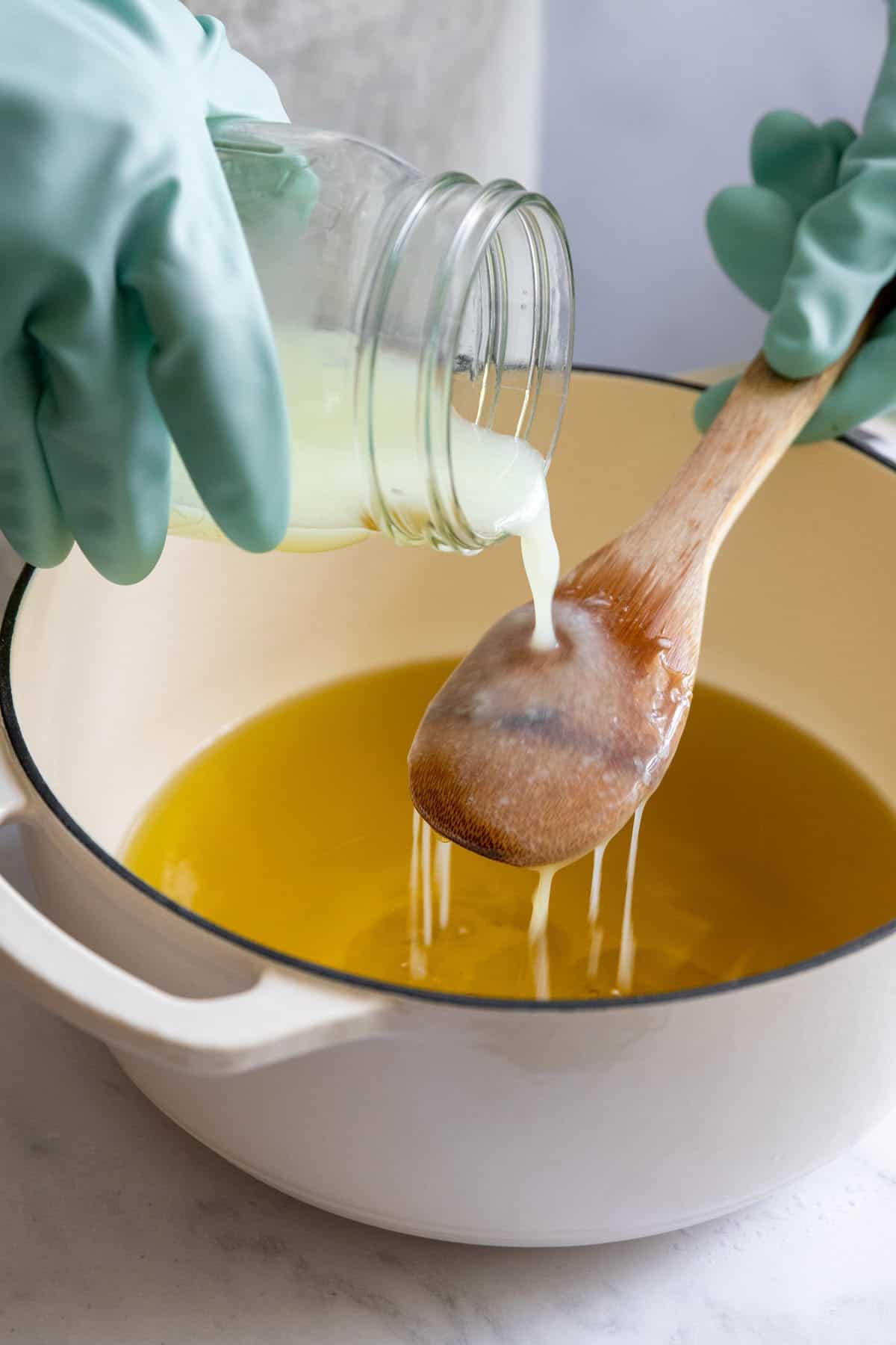 Pour lye solution into melted oils and butters