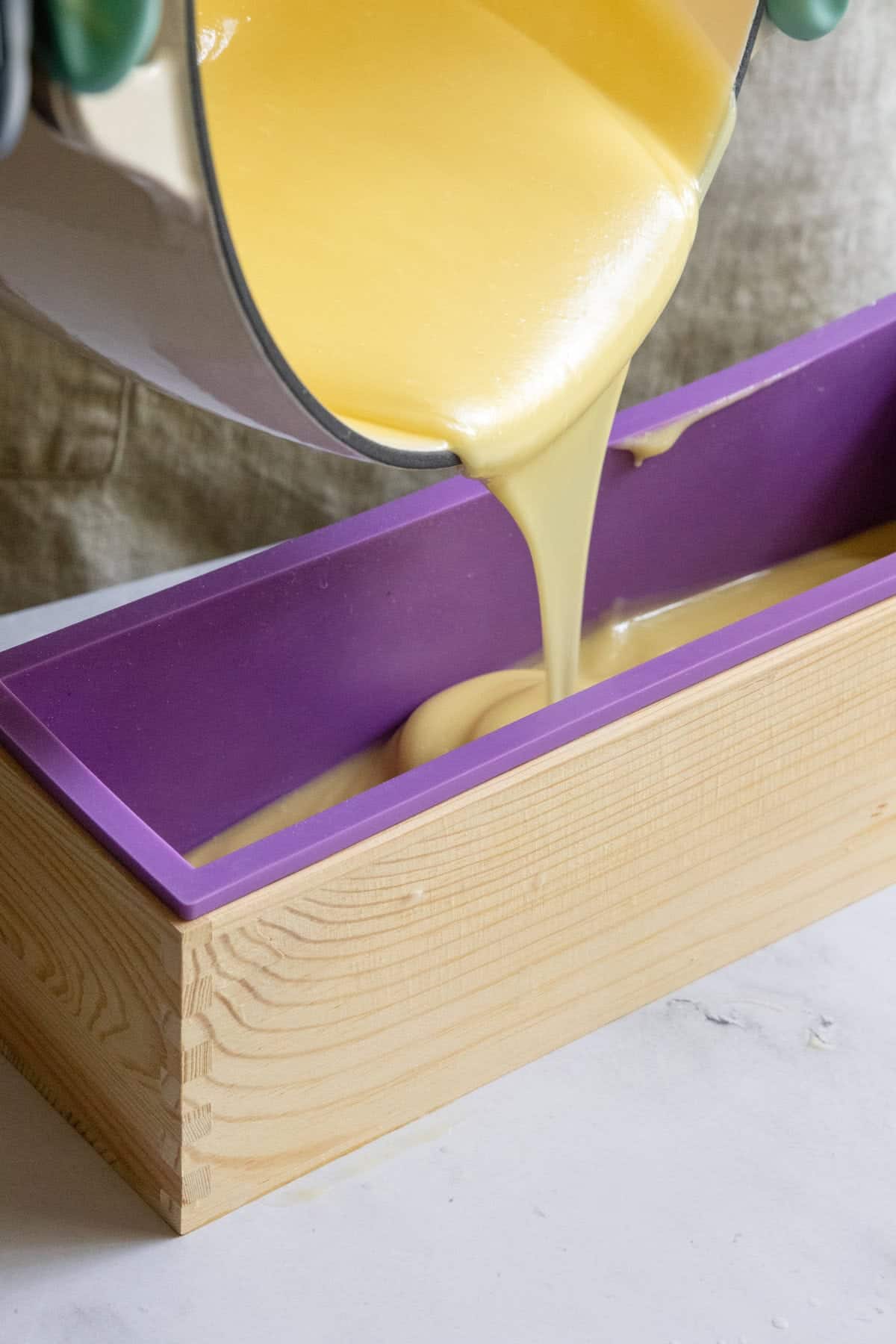 pouring goat milk soap into loaf container